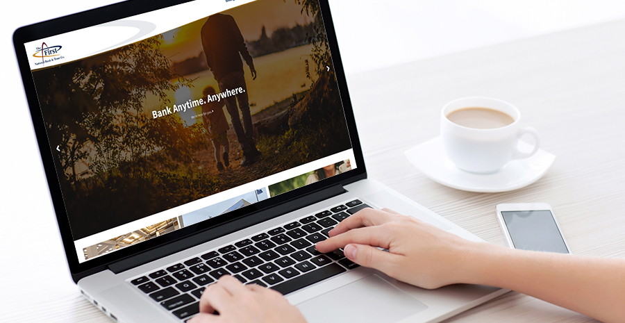 image of woman’s hands on computer with bank website showing