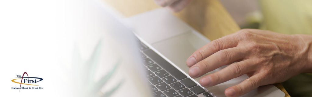 Man using a computer for FNBT business online banking and financing accounts