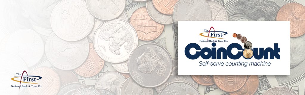 Image of U.S. coins spread out on a table. Our CoinCount logo is showing.